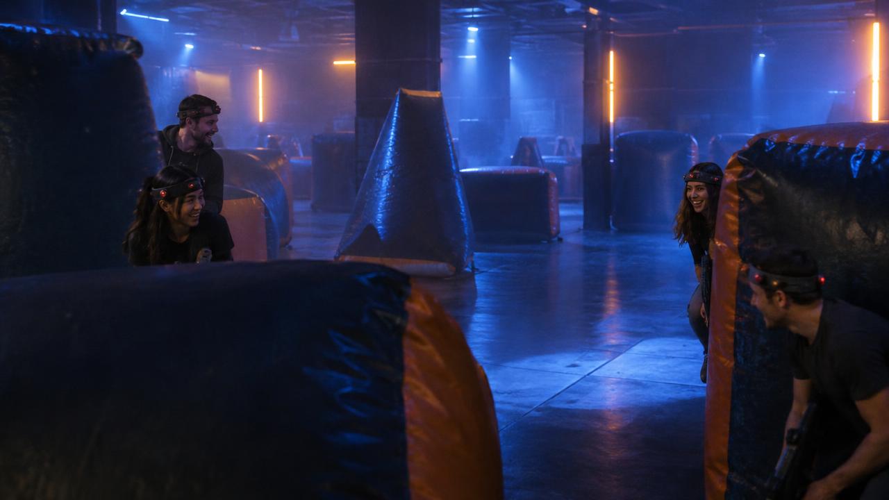 Illustrative lifestyle photograph of friends playing laser tag in an arena