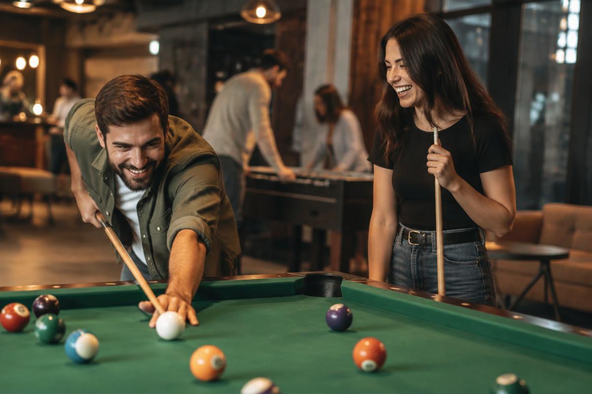 Illustrative lifestyle photograph of two friends playing a game of pool